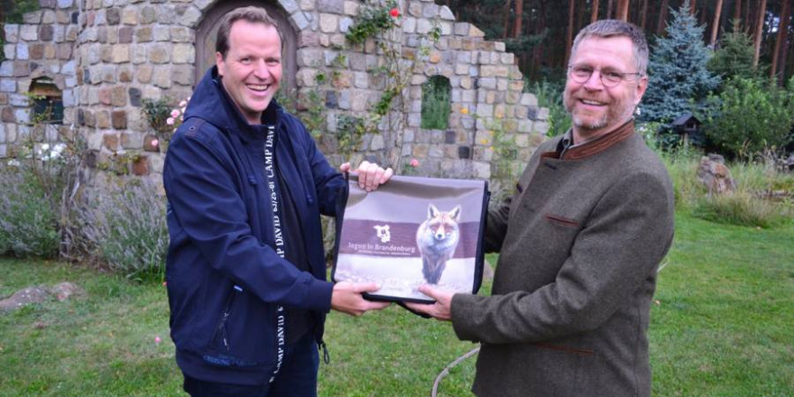 Während der Veranstaltung überreicht Präsidiumsmitglied Jörg Stendel (r.) ein Begrüßungsgeschenk an Frank Neumann, den Vorsitzenden von Rehkitzrettung Brandenburg e.V. (Foto: Hamann/LJVB)