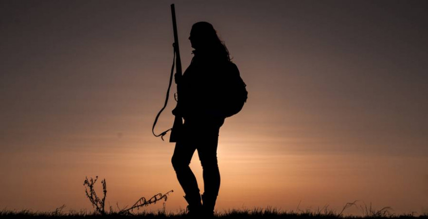 Jägerin mit Rucksack und Jagdgewehr im Abendrot (Symbolbild: rabit023)