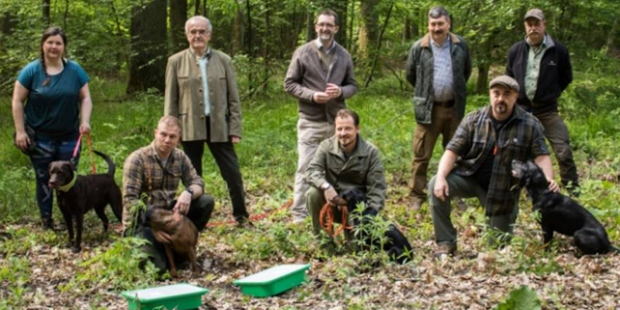 Auf dem Bild sieht man Umweltminister Reinhold Jost mit den auszubildenden Kadaversuchhunden des VJS. (Foto: (c) S. Schorr, MUV)