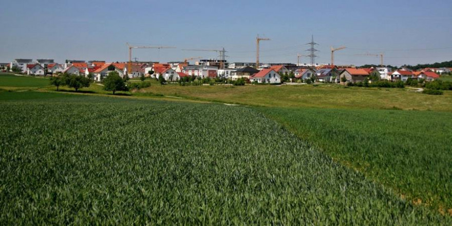 Ein Dorf mit Baukränen umrahmt von Feldern (Symbolbild_Catkin)