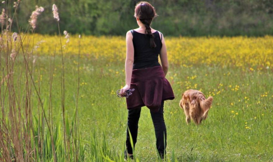 Eine Frau mit einem nicht angeleinten Hund (Symbolbild: pasja1000)