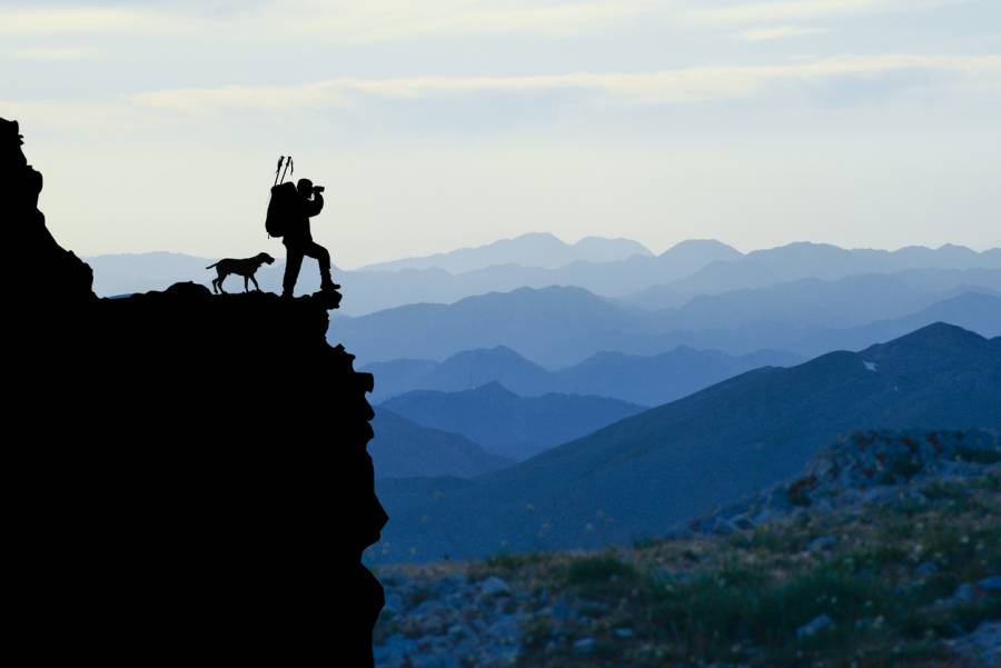 Mann mit Hund in felsigem Gelände (Symbolbild: 