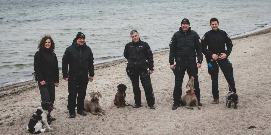 Auf dem Gruppenbild sind Ambra, Sky, Käthe, Lilli und Koko mit ihren Hundeführern zu sehen. (Foto: POL-SH-AFB)