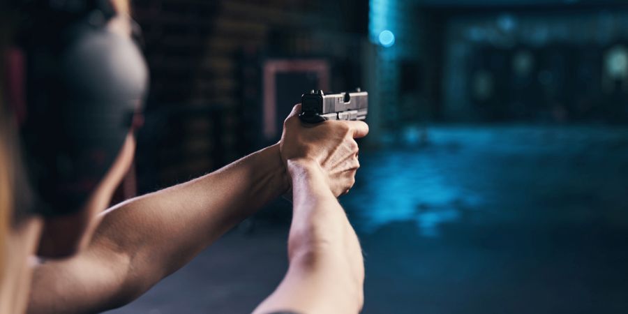 Eine Sportschützin mit einer Pistole im Anschlag auf einem Schießstand (Symbolbild: iStock/Svitlana Hulko)