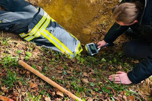 Halb im Bau verschwunden versucht ein Feuerwehrmann Kontakt zum eingeschlieften Hund zu bekommen. (Foto: Feuerwehr Bonn)
