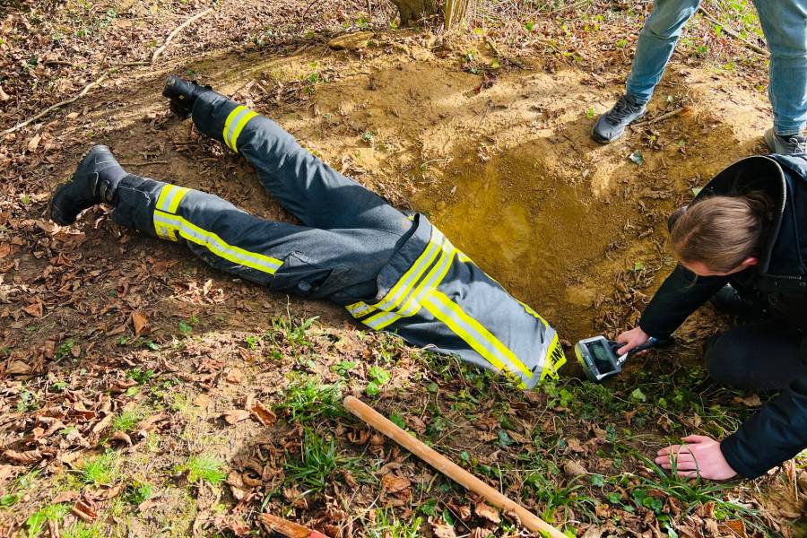 Halb im Bau verschwunden versucht ein Feuerwehrmann Kontakt zum eingeschlieften Hund zu bekommen. (Foto: Feuerwehr Bonn)