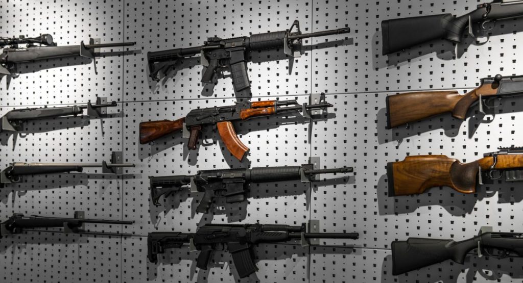 Unterschiedliche halbautomatische Gewehre und Repetierbüchsen an einer Wand hängend. (Symbolbild: iStock/SolidMaks)