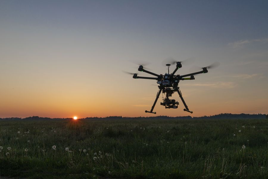 Eine Drohne mit Wärmebildtechnik bei Sonnenaufgang über einer Wiese. (Beispielbild: iStock/Sophie Linckersdorff)