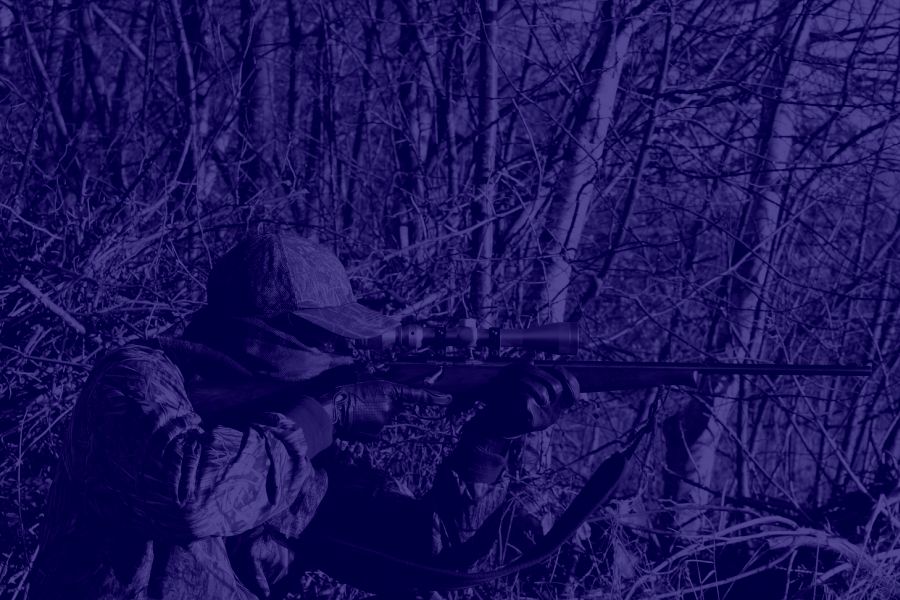 Ein vermummter Mann in Tarnkleidung hat ein Jagdgewehr mit Zielfernrohr im Anschlag. (Symbolbild: mtorben)