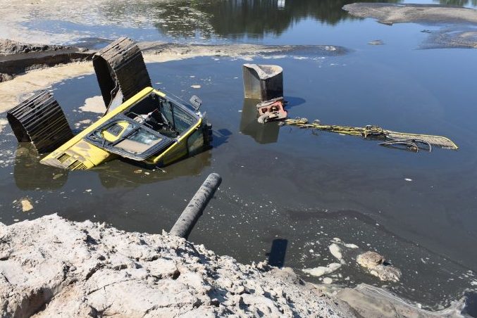 Durch das abfließende Wasser kippte der Bagger auf die Seite. (Foto: Polizei)