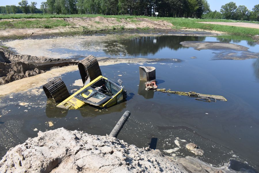 Durch das abfließende Wasser kippte der Bagger auf die Seite. (Foto: Polizei)