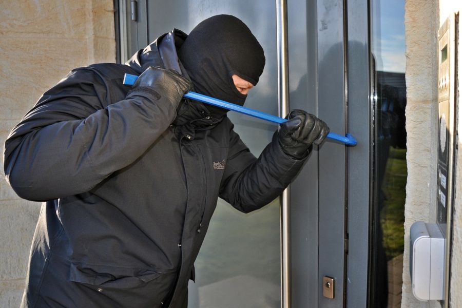 Ein Einbrecher hebelt mit einem Brecheisen eine Eingangstüre auf. (Symbolbild: Steffen Salow auf Pixabay)