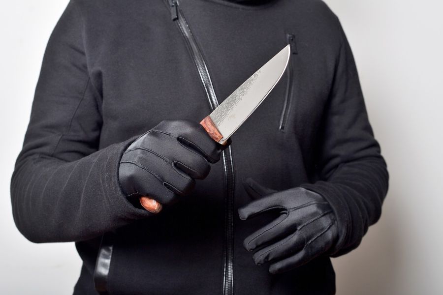 Ein schwarz gekleideter Mann mit schwarzen Handschuhen hält ein Messer in der rechten Hand. (Symbolbild: Leo auf Pixabay)