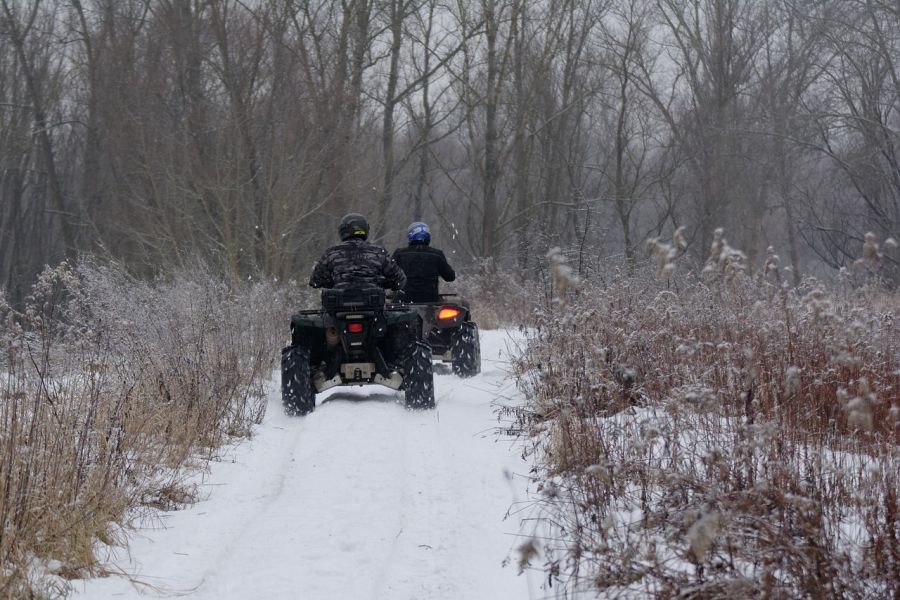 Zwei Quad-Fahrer, die mit ihren Fahrzeugen einen verschneiten Waldweg befahren. (Symbolbild: utroja0 auf Pixabay)