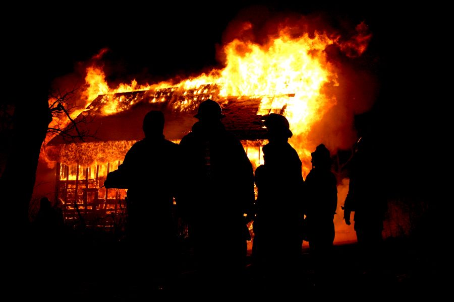 Eine Scheune brennt lichterloh. Feuerwehrleute überwachen das Geschehen. (Symbolbild: iStock/snapshotz)