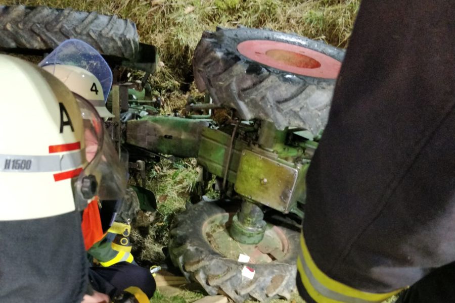 Der im Graben liegende Traktor mit beteiligten Rettungskräften der Freiwilligen Feuerwehr Hürtgenwald. (Foto: FFW Hürtgenwald) 