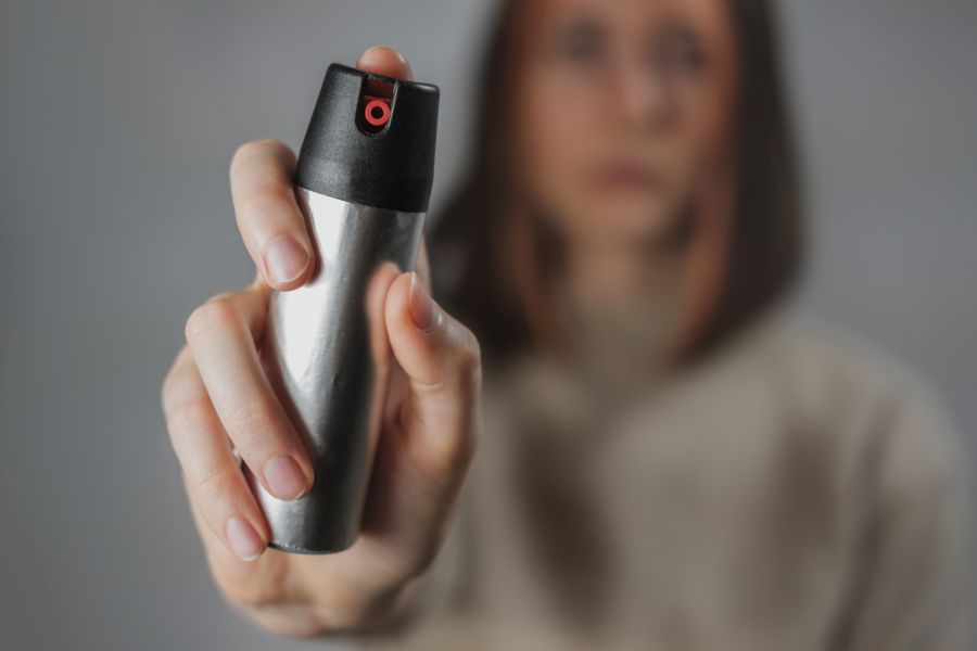 Eine Frau, die eine Dose mit Tränengas in der Hand hält und nach vorne streckt. (Symbolbild: iStock/Photoboyko)